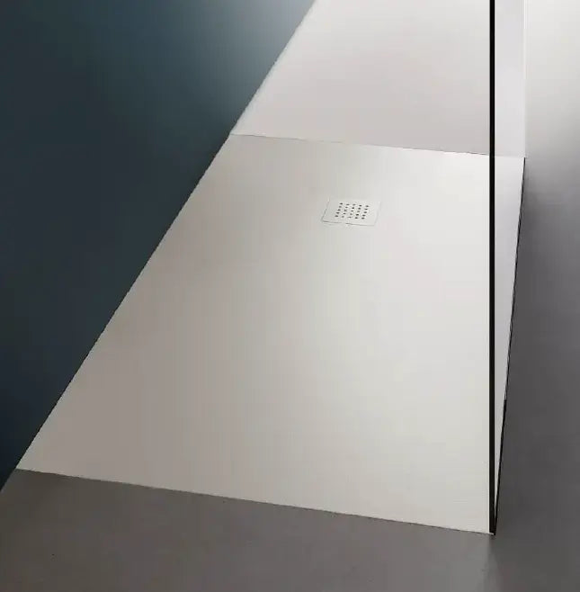 Piatto doccia in ceramica 3cm bianco matt con griglia di scarico inox rettangolare, in angolo doccia con parete blu petrolio