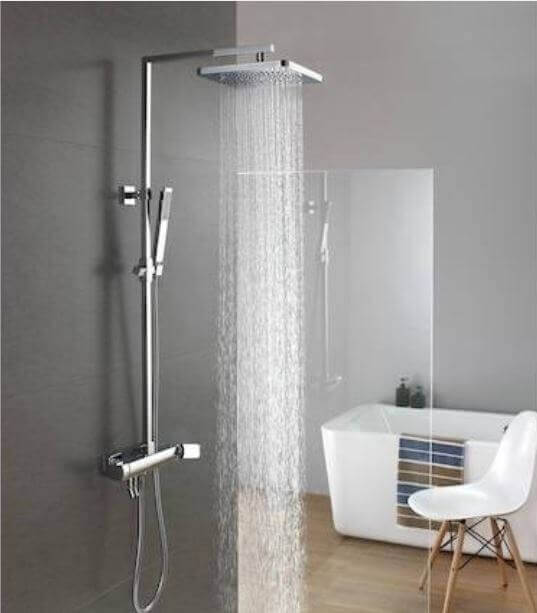 Colonna doccia termostatica con soffione quadrato in box doccia con vasca sullo sfondo