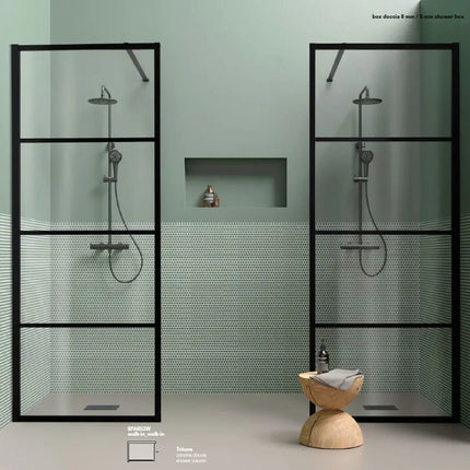 Due pareti doccia walk-in con telaio finestrato nero su parete verde salvia con nicchia e sgabello in legno