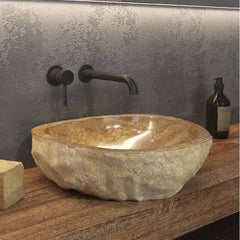 Lavabo da appoggio in onice naturale scolpito a mano Karag serie Onyx: esterno grezzo irregolare, interno lucidato a scodella, su piano legno