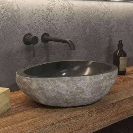 Lavabo da appoggio in pietra di fiume naturale grigio Karag River 40-45cm: esterno grezzo, interno scuro lucidato, su piano legno con rubinetteria nera