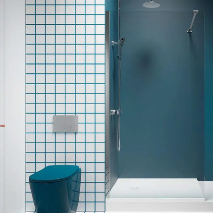 Parete doccia walk-in 6mm in bagno con piastrelle bianche a fughe blu, parete turchese e sanitari colorati