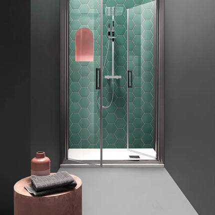 Porta doccia saloon FPSL60 6mm nicchia H200cm, vista frontale con piastrelle esagonali verde acqua e sgabello in legno davanti