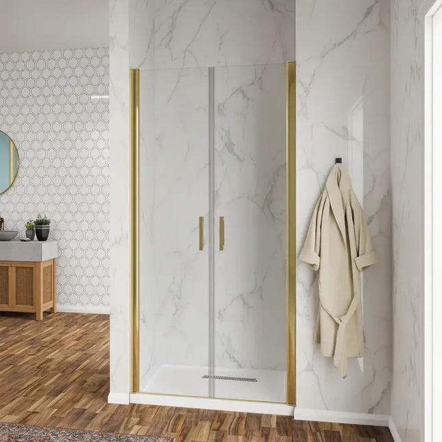 Porta doccia saloon H190 cristallo trasparente 6mm profili oro, doppia anta con maniglie dorate, in bagno con rivestimento marmo bianco