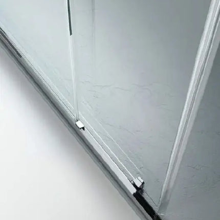 Dettaglio binario inferiore porta doccia QUICK 6mm: profilo cromato a pavimento con guarnizione su piatto effetto marmo bianco